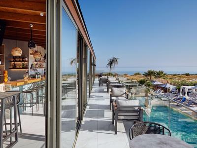 Moderner Poolbereich mit Lounge und Bar in einem Hotel bei klarem Himmel