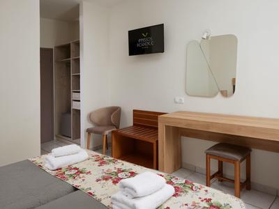 Helles, modernes Schlafzimmer mit floralem Teppich, hellbraunem Mobiliar und neutralen Wänden.