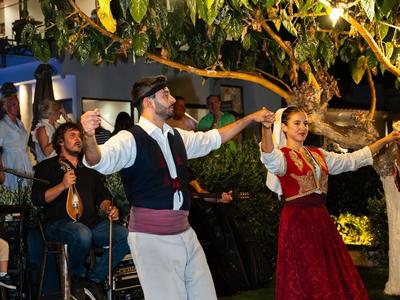 Paar tanzt traditionell im Garten bei Nacht unter Lichterketten.