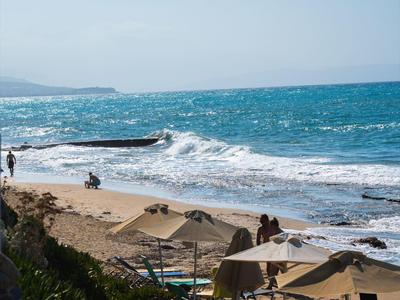 Playa con tumbonas, sombrillas y mar tranquilo bajo cielo despejado.