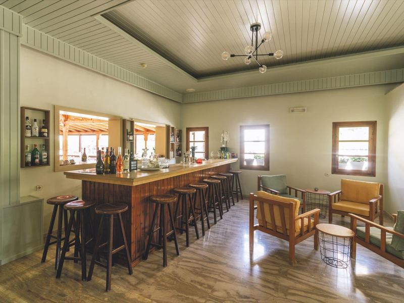 Gezellige hotelbar met houten meubels en veel natuurlijk licht.