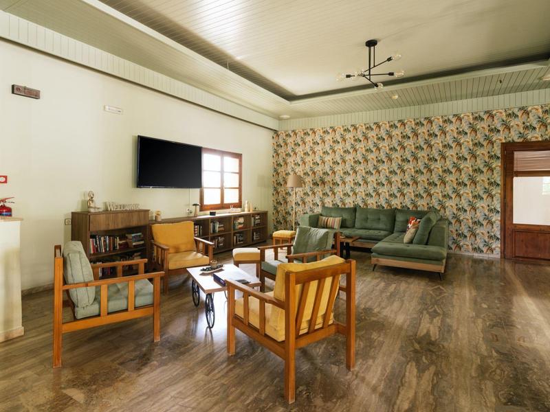 Gezellige zitruimte met banken, fauteuils en tv in een hotel.