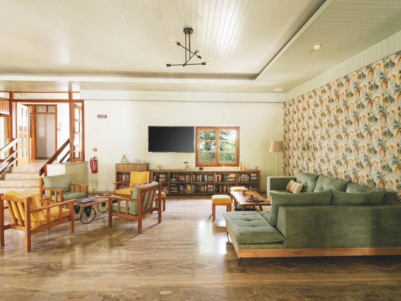 Modern ingerichte hotel lounge met zitplaatsen en een aan de muur gemonteerde tv.