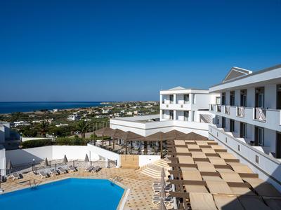 Complesso alberghiero moderno con piscina e vista mare sotto un cielo azzurro