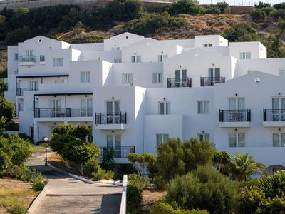 Edificio dell'hotel bianco con più balconi in un paesaggio collinare.