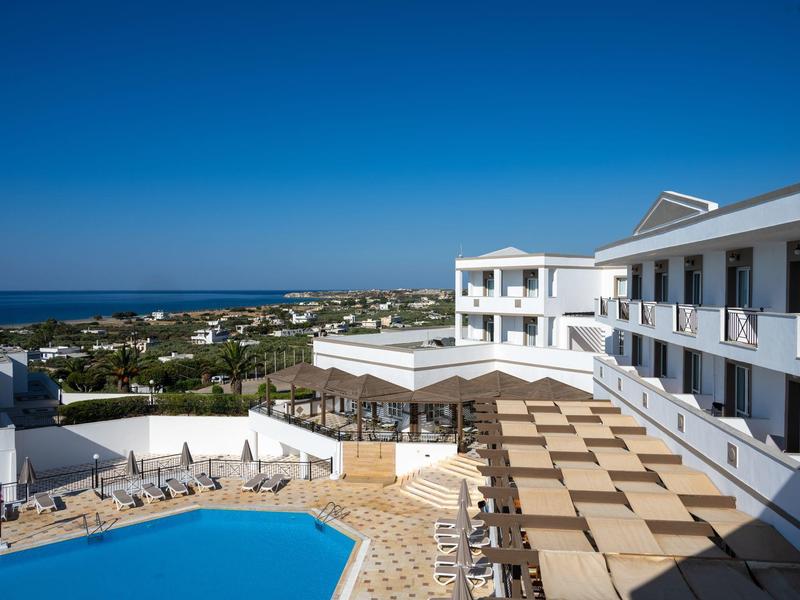 Complesso alberghiero moderno con piscina e vista mare sotto un cielo azzurro