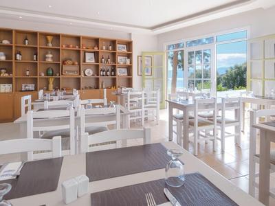 Heller Speiseraum mit weißen Holzmöbeln und großer Holzwandvitrine mit Geschirr.