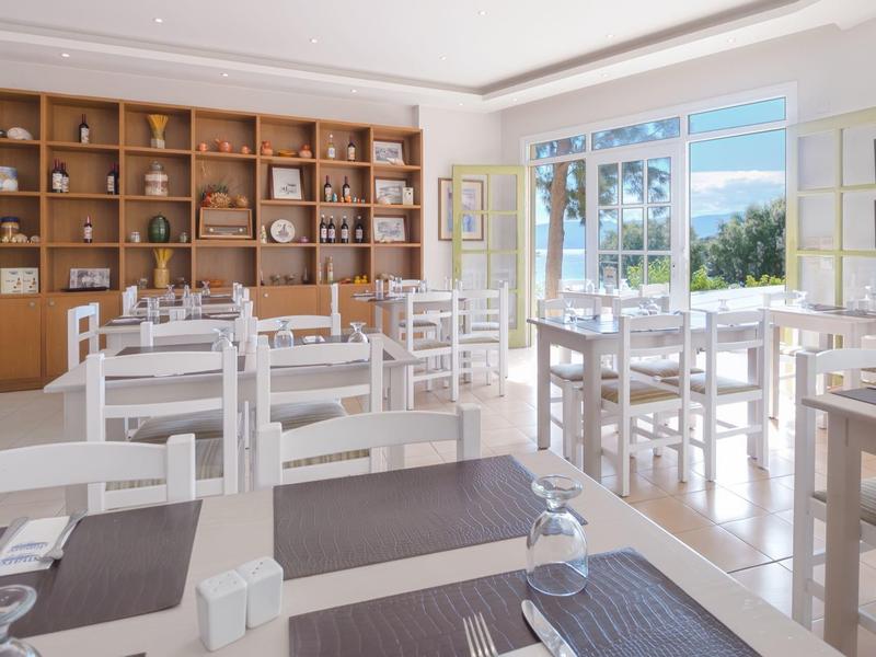 Heller Speiseraum mit weißen Holzmöbeln und großer Holzwandvitrine mit Geschirr.