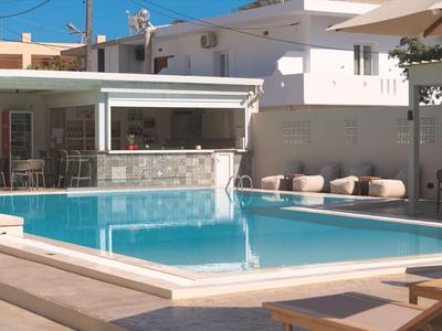 Nowoczesny zewnętrzny basen z parasolami, miejscami do siedzenia i przyległym barem w hotelu.