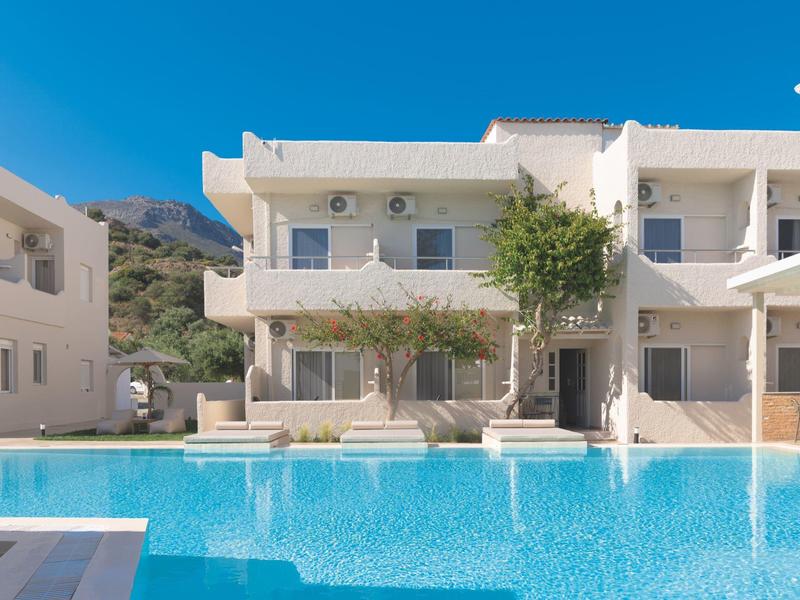 Nowoczesne białe apartamenty wakacyjne z balkonami i dużym basenem pod czystym niebem.