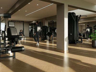 Moderner Fitnessraum mit Kraftgeräten und großen Fenstern, die Tageslicht hereinlassen.