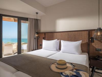 Modernes Hotelzimmer mit Doppelbett, Strandblick und minimalistischem Design.