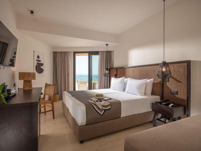Modernes Hotelzimmer mit großem Bett, Meerblick und neutralen Farben.