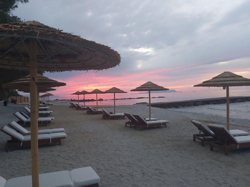Beach with loungers and umbrellas at sunset by the sea.