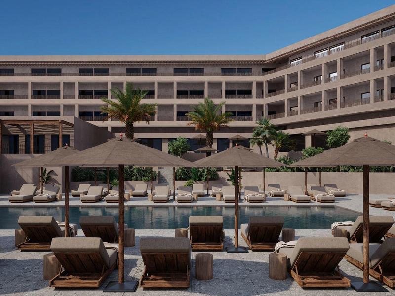 Modern hotel pool with loungers and umbrellas surrounded by a multi-story building.