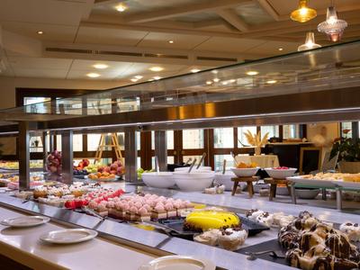 Buffetgedeelte in een hotel met een selectie desserts en borden op een lange tafel.
