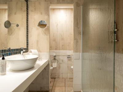 Moderne badkamer met wastafel, spiegels en douche in een hotel.
