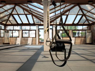 Heldere sportschool met houten structuur en turnringen, ideaal voor sportactiviteiten in het hotel.