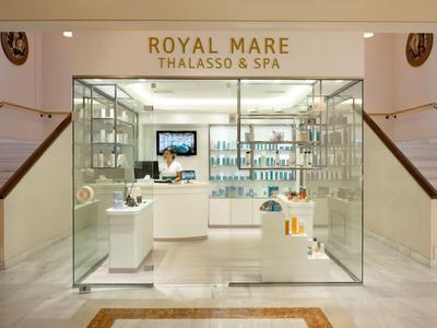 Duidelijke glazen gevel van een spa-winkel met producten en receptie in een hotel.