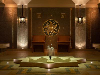 Een elegante hotel lounge met symmetrische verlichting en een centrale fontein.