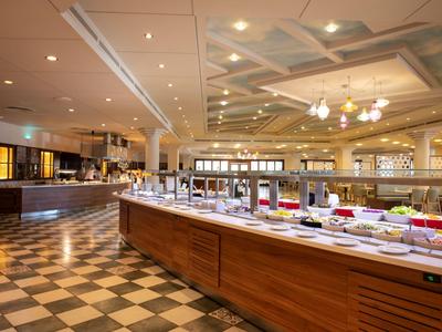 Grote, elegante hotel eetzaal met buffet en geruit vloerkleed.