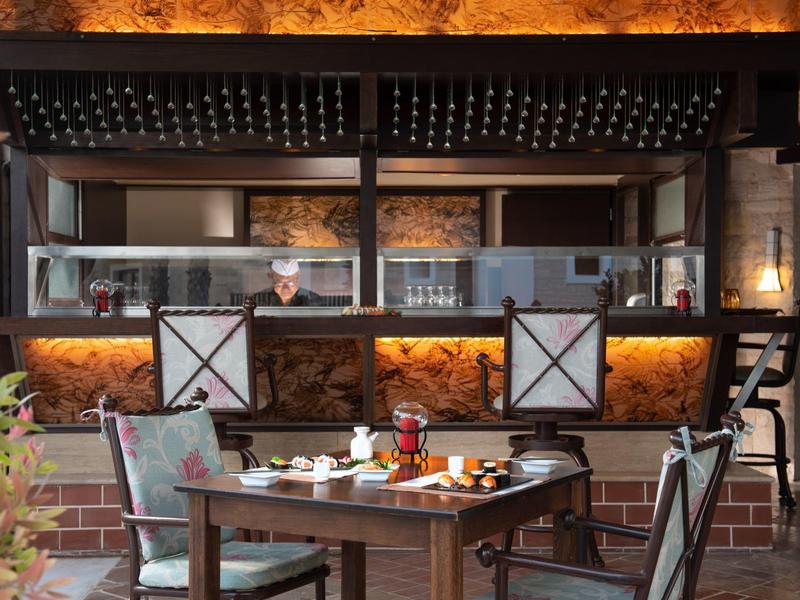 Příjemný interiér restaurace s dřevěným nábytkem a teplým osvětlením.