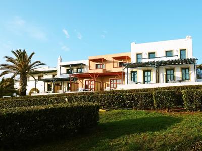 Modernes Hotelgebäude mit großen Fenstern und Palmen im Vordergrund bei sonnigem Wetter