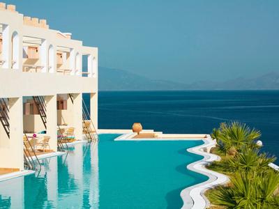 Infinity-Pool an einem Hotel mit Blick auf das blaue Meer und klare Himmel.