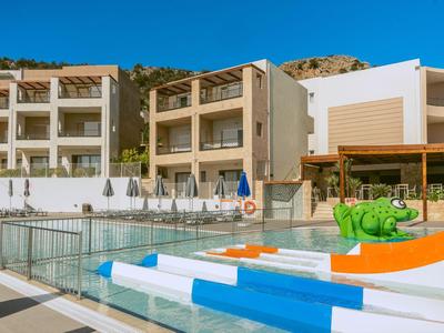 Moderner Hotelpoolbereich mit Rutschen, Sonnenschirmen und mehrstöckigen Gebäuden im Hintergrund.