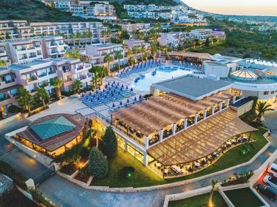 Großes Hotelresort mit Pool, Terrassen, Sonnenliegen und umgeben von grünen Hügeln bei Abendlicht.