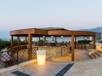 Elegante Freiluftlounge mit Holzpergola und Panoramablick am Hotelpool.