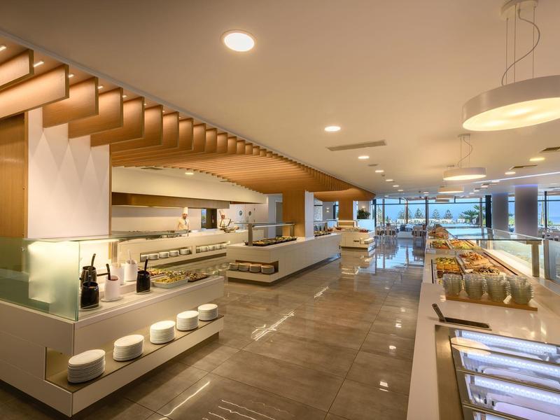 Buffet de hotel moderno con diseño cálido de madera y variedad de alimentos en un espacio iluminado.