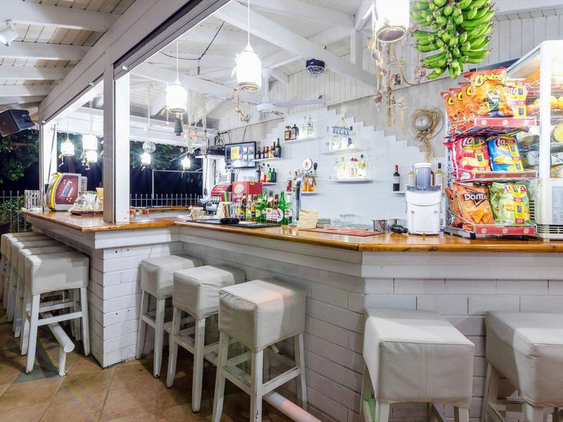 Moderní bar s vysokými stoličkami a dobře zásobenými občerstveními a nápoji.