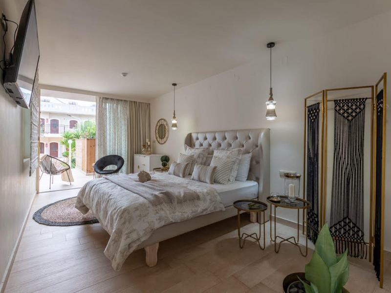 Světelná ložnice s velkou postelí, balkonem a moderním zařízením.