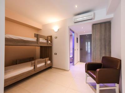 Kleines Zimmer mit Etagenbett, Sessel und integriertem Bad in modernem Stil.