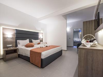 Modern eingerichtetes Hotelzimmer mit großem Bett, Schreibtisch und gemütlicher Beleuchtung.