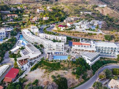 Große Hotelanlage mit Pools, weißen Gebäuden und Straßen in hügeliger, grüner Landschaft.
