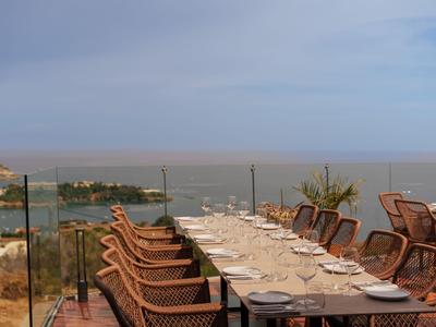 Gemütliche Terrasse mit gedecktem Tisch und Blick auf das Meer und die Küstenstadt.