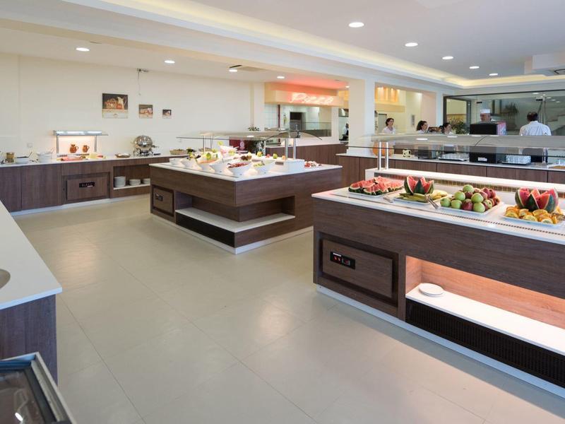 Bufetová oblast s různými pokrmy a moderním, světlým interiérem v hotelu.
