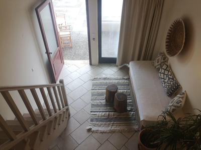 Hotelzimmer mit Sofa, Teppich, Holztischchen und offener Tür zum Balkon oder Terrasse.