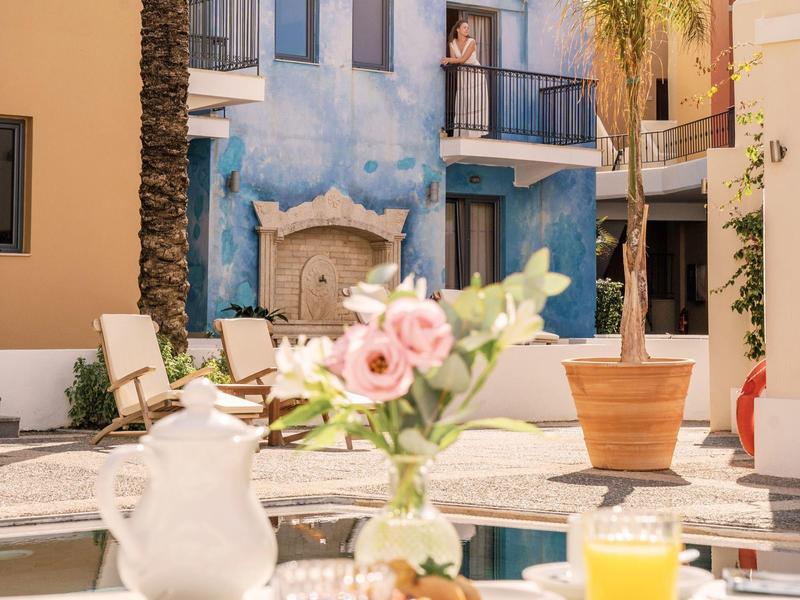 Innenhof mit Sitzgelegenheiten, einem Springbrunnen und Pflanzen in einem Hotel.
