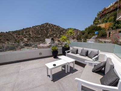 Moderne buitenzitset op een ruim terras met bergzicht bij heldere lucht