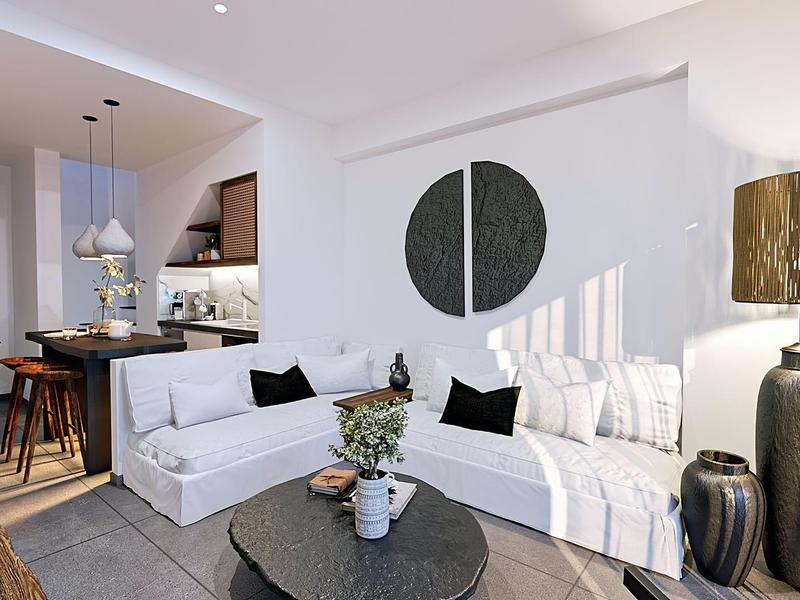 Lichte woonkamer met witte banken, ronde tafel en open keuken op de achtergrond