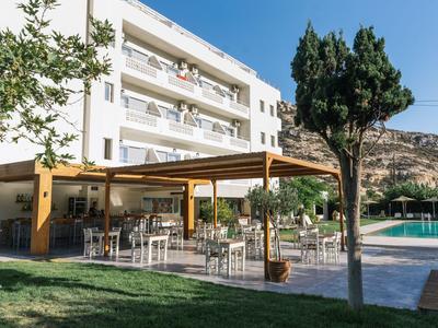 Área exterior moderna de hotel con terraza y piscina bajo un cielo despejado.