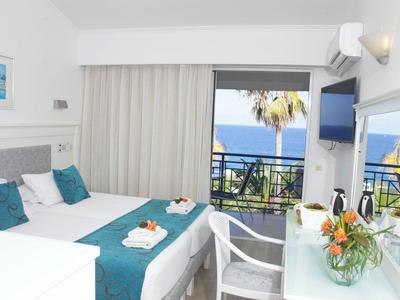 Nowoczesny pokój hotelowy z podwójnym łóżkiem, balkonem i widokiem na morze, jasny i przytulny.