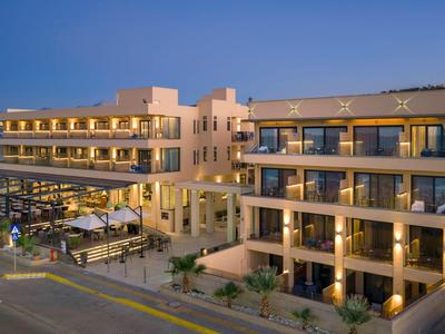 Nowoczesny hotel z balkonami i przestrzenią na zewnątrz pod czystym wieczornym niebem.