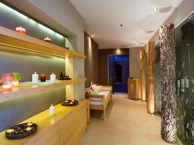 Heller, moderner Wellnessraum mit Kerzen, bequemen Möbeln und beruhigender Atmosphäre.