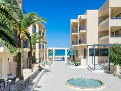 Nowoczesne patio hotelowe z palmą, fontanną i widokiem na błękitne morze pod bezchmurnym niebem.