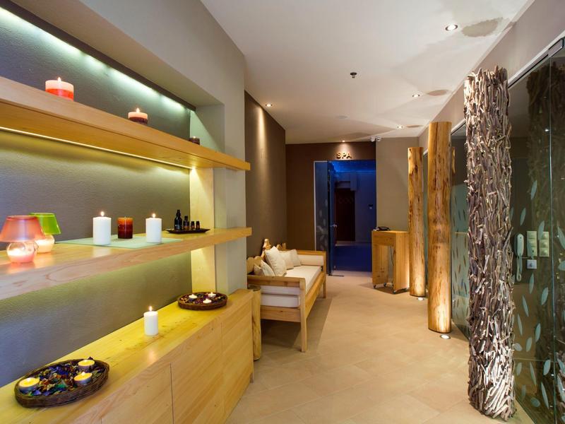 Heller, moderner Wellnessraum mit Kerzen, bequemen Möbeln und beruhigender Atmosphäre.