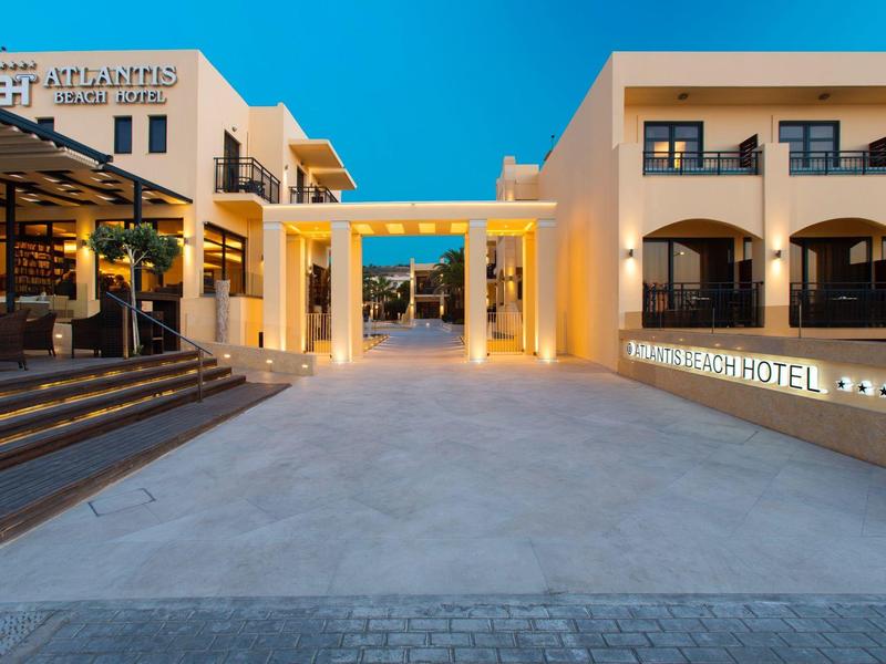 Moderner, lichtdurchfluteter Hoteleingang mit klaren Linien und warmem Beleuchtungskontrast bei Dämmerung.